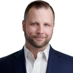 Corporate headshot of Chuck Sierk with short brown hair styled with trimmed brown beard wearing navy blue suit jacket over white dress shirt photographed against white studio background by Richard Waine Photography Lancaster PA