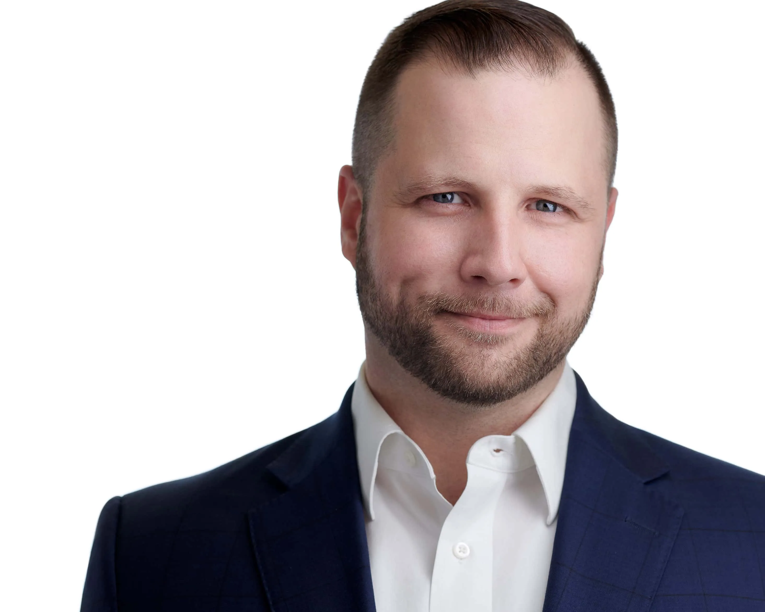 Male professional executive headshot with short styled brown hair, neatly trimmed beard, blue eyes, wearing navy blue suit jacket with crisp white dress shirt, genuine confident approachable smile, photographed on seamless white background by Lancaster Pennsylvania headshot photographer Richard Waine