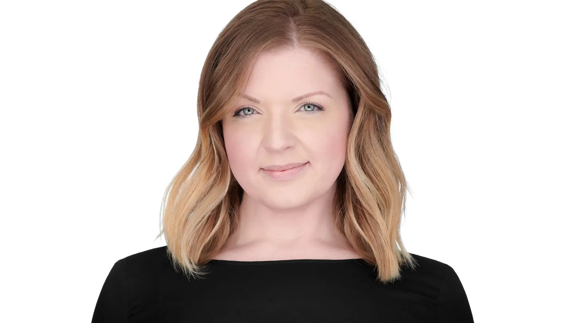 Professional headshot of female with shoulder-length wavy blonde ombre hair, subtle smile, wearing black boat neck top, photographed on seamless white background in Lancaster, Pennsylvania by headshot photographer Richard Waine