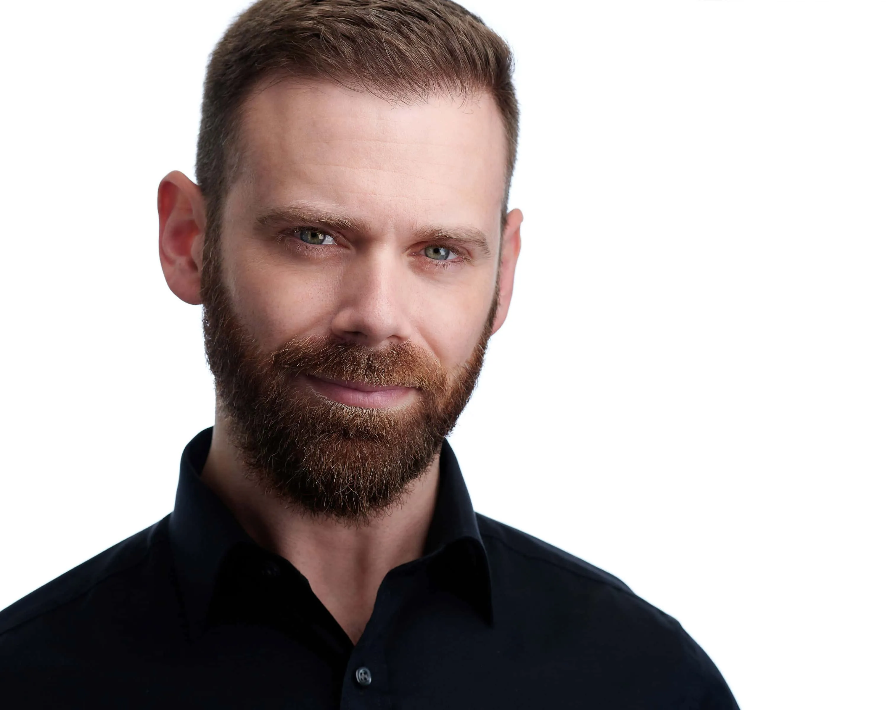 Professional Headshot of a caucasian male wearing a black button down shirt displaying a confident facial expression