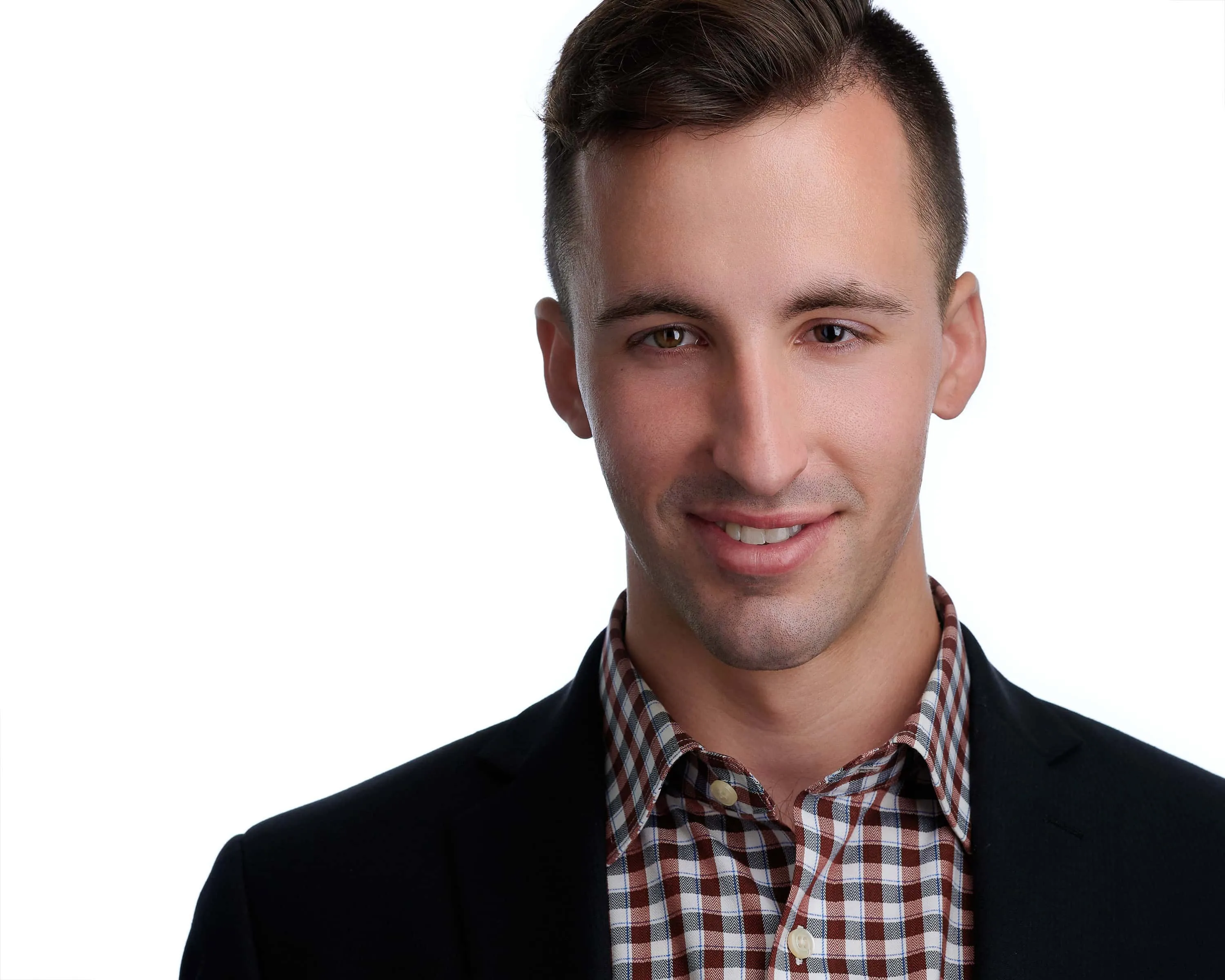 Male construction industry professional headshot with dark brown hair short on sides, wearing black sport coat over brown white and orange plaid button-down shirt, photographed on seamless white background by Lancaster Pennsylvania photographer Richard Waine, former Amish business professional portrait