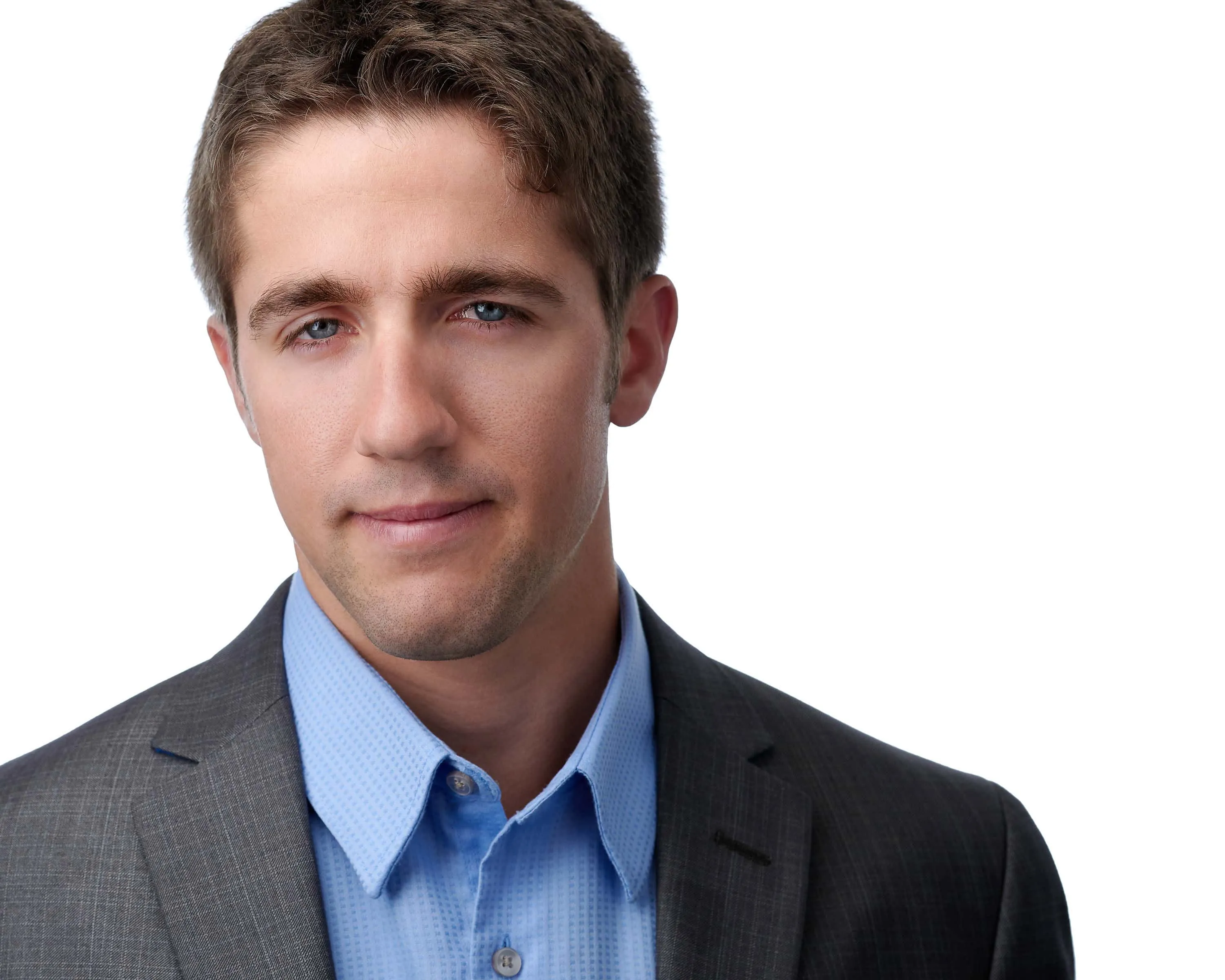Male professional headshot with short dark brown hair, wearing charcoal grey suit jacket over light blue dress shirt, photographed on seamless white background by Lancaster Pennsylvania headshot photographer Richard Waine