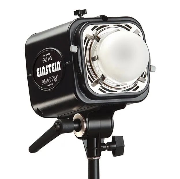 Paul C Buff Einstein E640 studio strobe light monolight with black housing mounted on black light stand, white bulb exposed at front opening, professional photography lighting equipment used for white background illumination